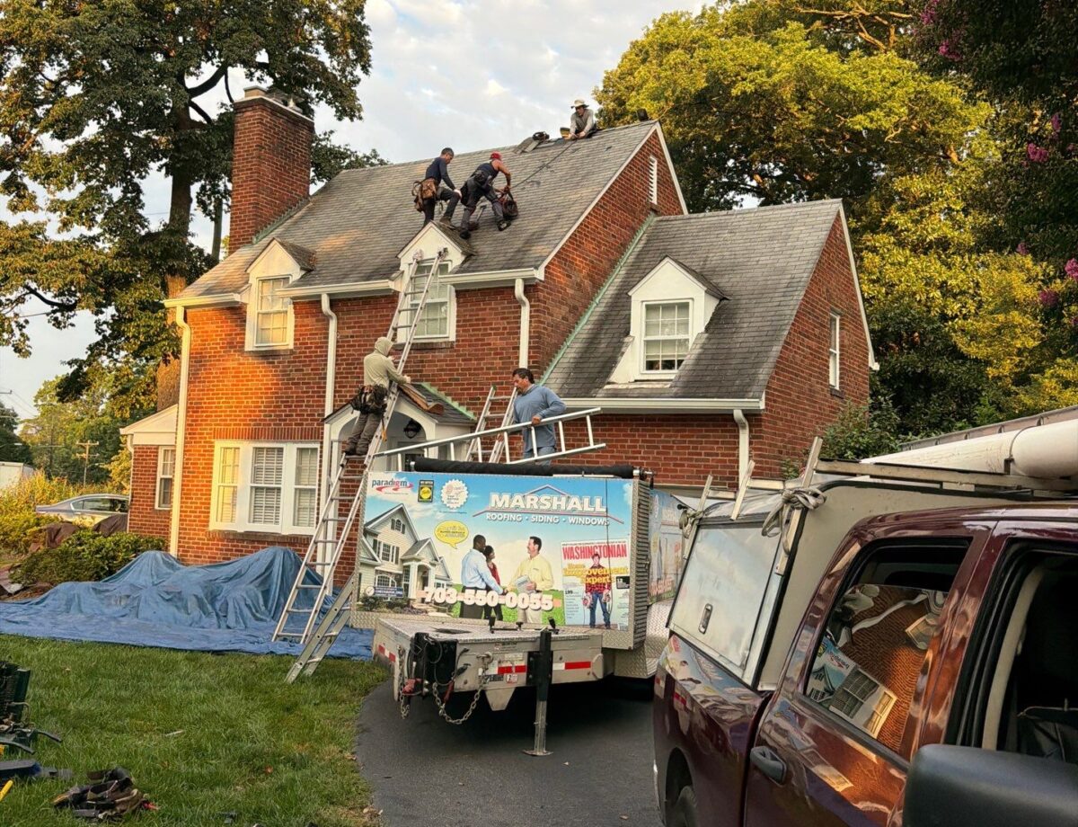 Roofing company in Fairfax, Virginia, with Marshall Roofing crew installing shingles on a brick home.