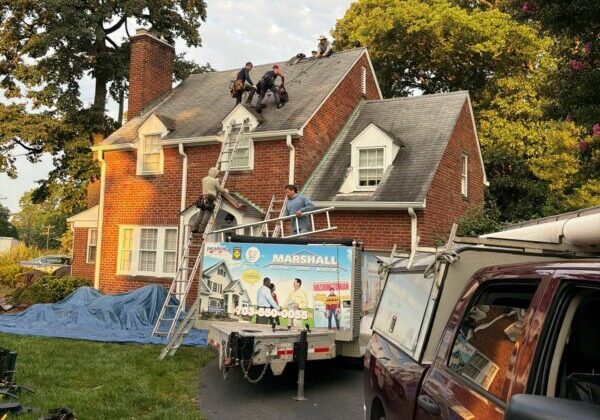 Roofing company in Fairfax, Virginia, with Marshall Roofing crew installing shingles on a brick home.